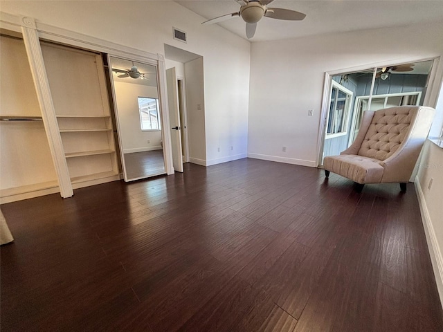 unfurnished room with dark wood finished floors, visible vents, and a ceiling fan