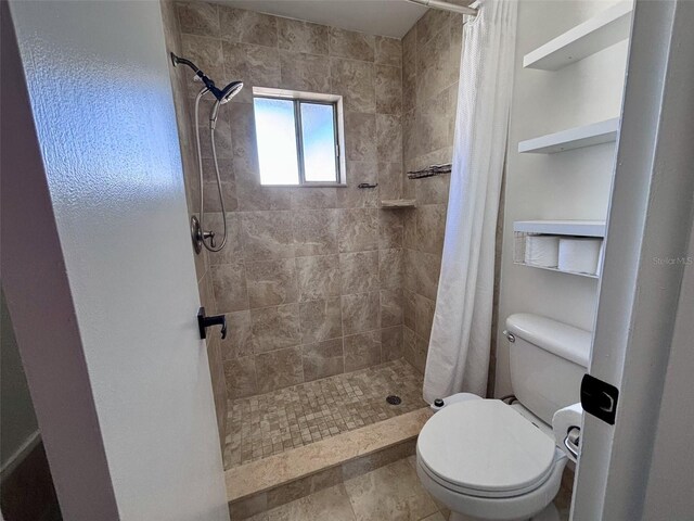 full bathroom with toilet and a tile shower