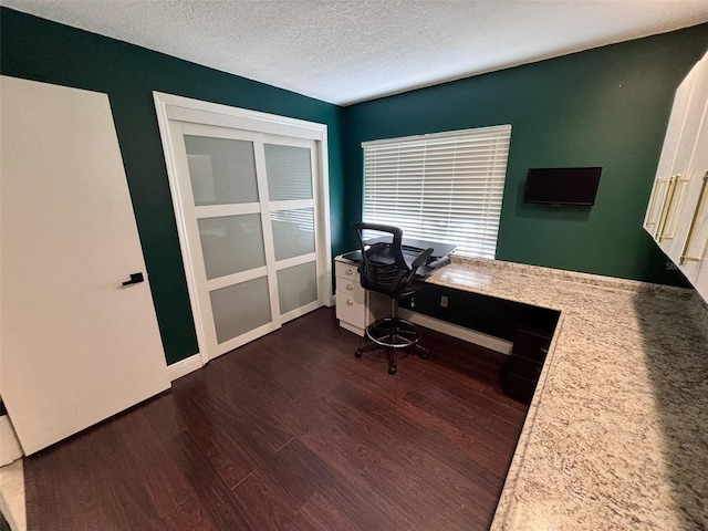 office space with dark wood-style floors, a textured ceiling, and baseboards