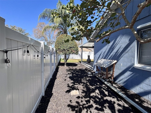 exterior space with concrete block siding and a fenced backyard