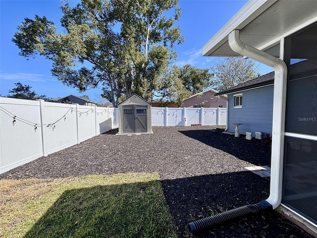 view of yard featuring an outbuilding, a fenced backyard, and a shed