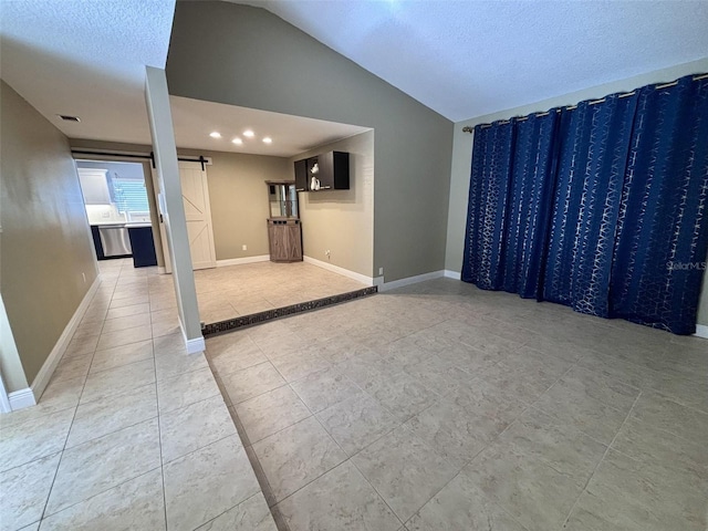 empty room featuring recessed lighting, a barn door, baseboards, light tile patterned floors, and lofted ceiling