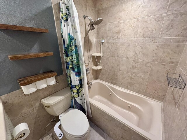 full bathroom with toilet, tile walls, a textured wall, and a combined bath / shower with jetted tub