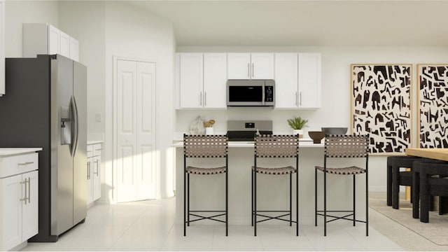 kitchen with stainless steel appliances, white cabinets, and a kitchen bar