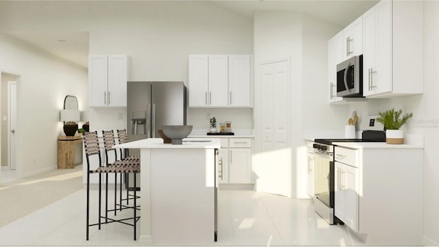 kitchen with appliances with stainless steel finishes, a kitchen breakfast bar, a center island, vaulted ceiling, and white cabinetry