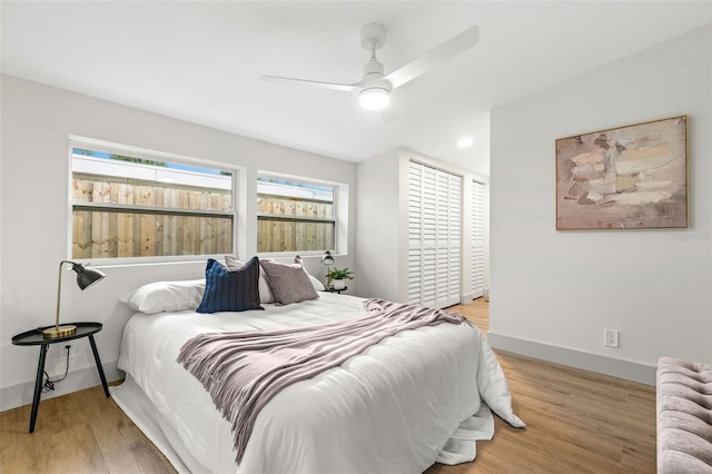 bedroom with wood finished floors, a ceiling fan, and baseboards