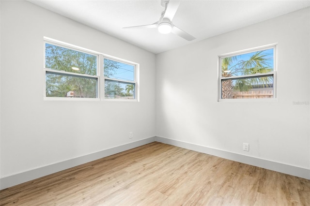 spare room with ceiling fan, wood finished floors, and baseboards