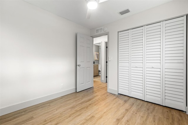 unfurnished bedroom with baseboards, visible vents, ceiling fan, light wood-style floors, and a closet