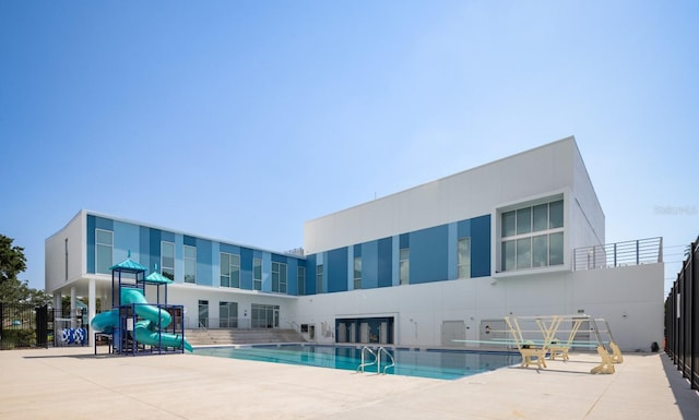 community pool featuring a patio area and a water slide