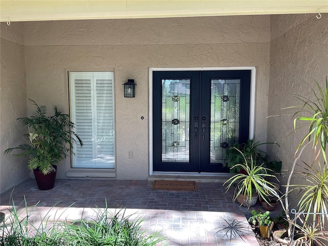 entrance to property with french doors and stucco siding