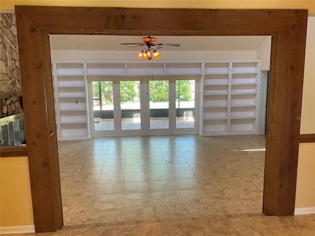 unfurnished room with built in shelves, ceiling fan, and tile patterned floors