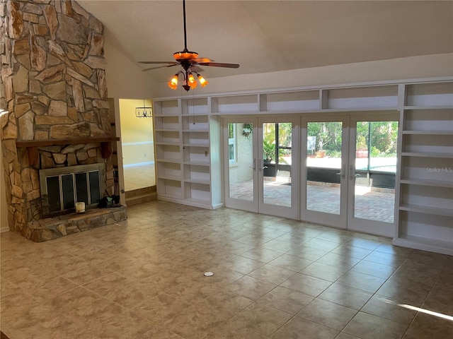 unfurnished living room featuring lofted ceiling, ceiling fan, a wealth of natural light, and a stone fireplace