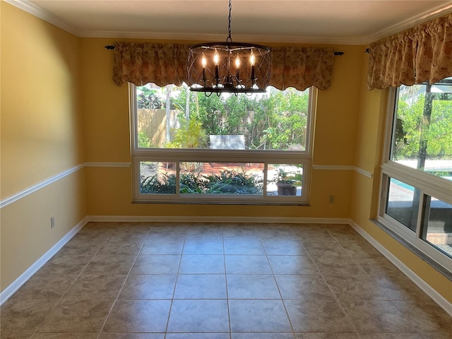 unfurnished dining area featuring crown molding, baseboards, and an inviting chandelier