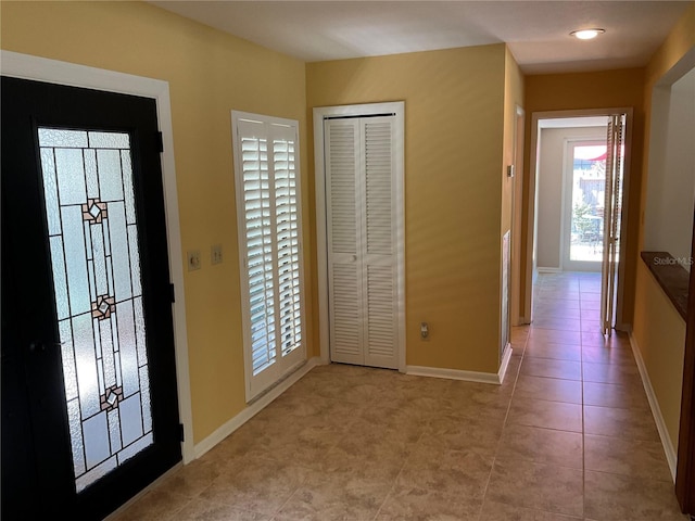 entryway featuring light tile patterned floors and baseboards