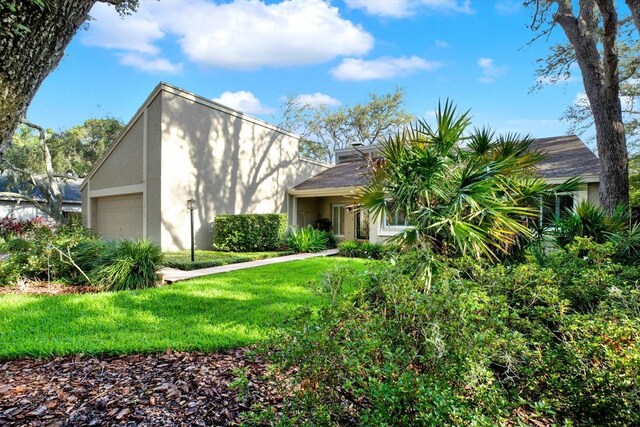 11712 Palmer Dr, Tampa, FL 33624 - view of front of home featuring stucco siding, a front yard, and an attached garage