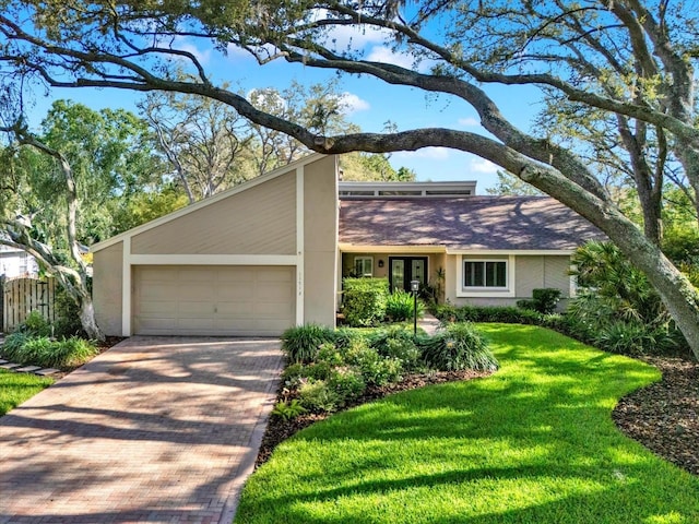 11712 Palmer Dr, Tampa, FL 33624 - mid-century inspired home with an attached garage, stucco siding, decorative driveway, and french doors