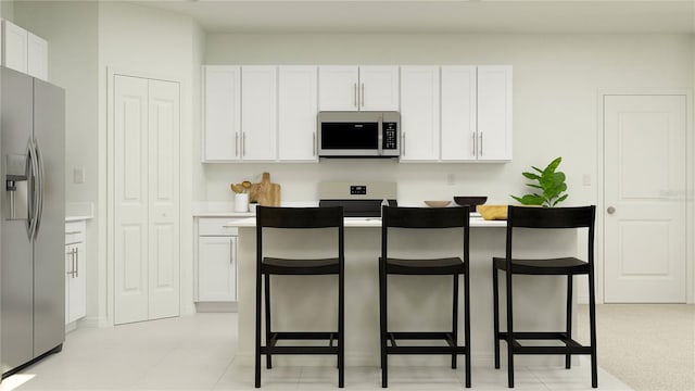 kitchen with white cabinets, appliances with stainless steel finishes, and a breakfast bar