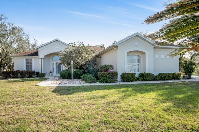 view of front facade with a front yard and stucco siding