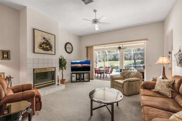 carpeted living area featuring visible vents, a ceiling fan, and a tile fireplace