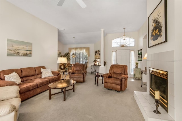 living area with light carpet, high vaulted ceiling, ceiling fan, and a tile fireplace