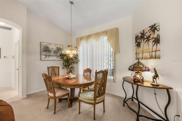 dining space featuring light carpet, visible vents, arched walkways, lofted ceiling, and a chandelier