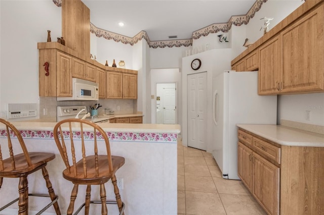 kitchen featuring white appliances, tasteful backsplash, a peninsula, light countertops, and light tile patterned flooring