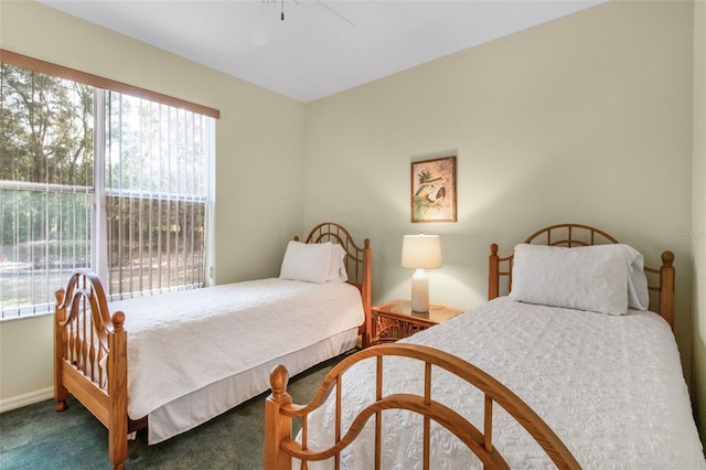 carpeted bedroom with ceiling fan and baseboards