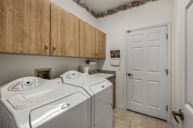 clothes washing area with light tile patterned floors, a sink, cabinet space, and washer and dryer