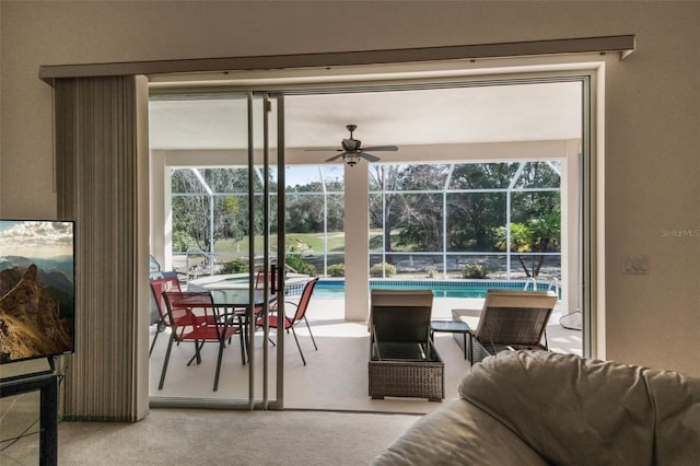 living area with a sunroom, plenty of natural light, carpet flooring, and a ceiling fan