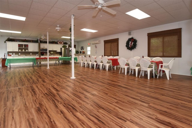 dining space featuring a paneled ceiling, ceiling fan, and wood finished floors