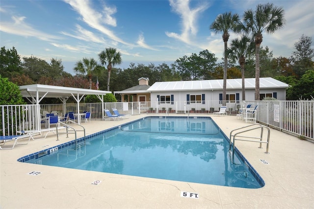 pool with a patio and fence