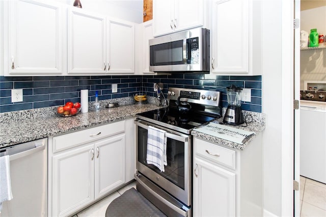 kitchen with decorative backsplash, light tile patterned flooring, white cabinetry, and stainless steel appliances