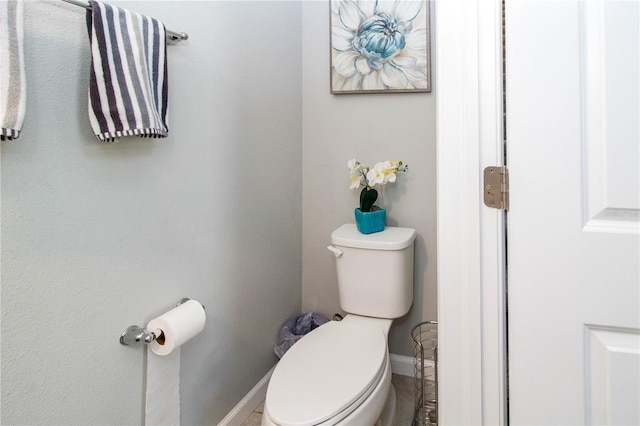 bathroom with toilet and baseboards