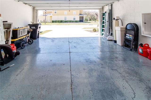 garage featuring electric panel and concrete block wall