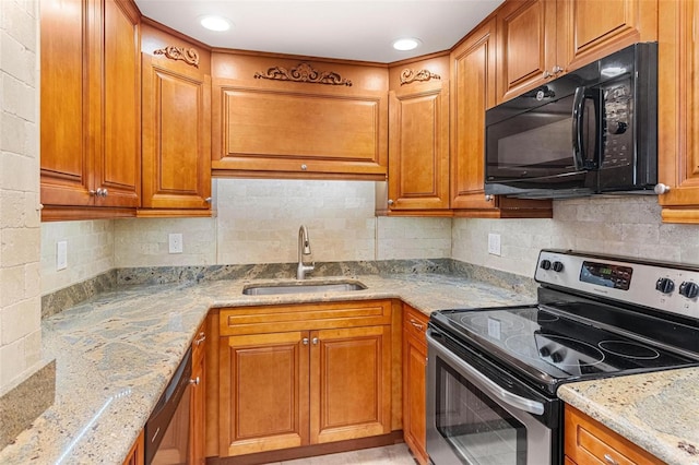 kitchen with a sink, stainless steel electric range, brown cabinetry, and black microwave