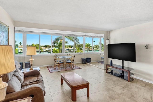 living room featuring a textured ceiling and baseboards