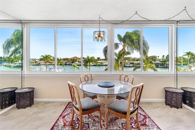 sunroom featuring a chandelier and a water view