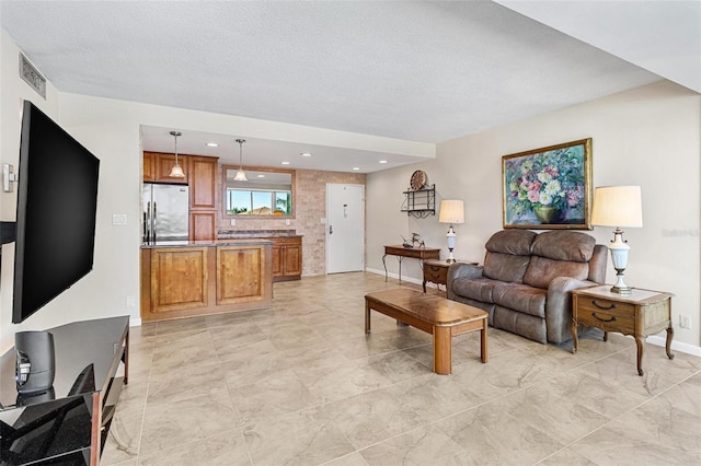 living area featuring visible vents, a textured ceiling, and baseboards