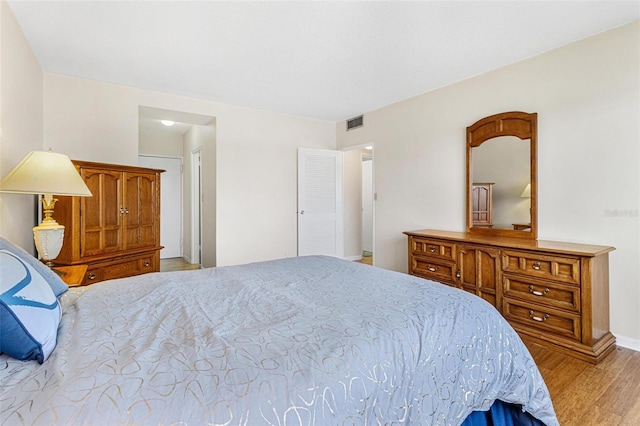 bedroom featuring visible vents and wood finished floors