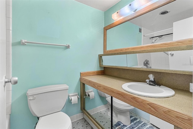 bathroom with tile patterned flooring, toilet, baseboards, and a sink