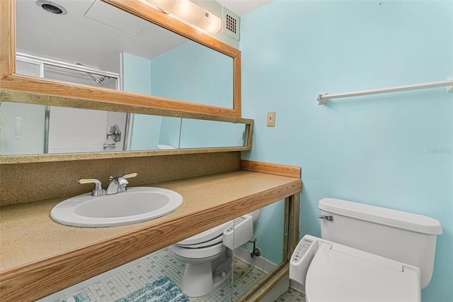 bathroom featuring tile patterned flooring, toilet, visible vents, and a sink