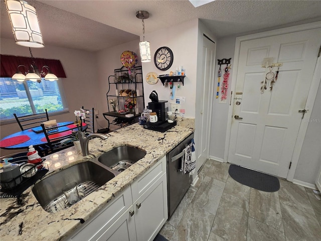 kitchen featuring a sink, pendant lighting, a textured ceiling, and stainless steel dishwasher