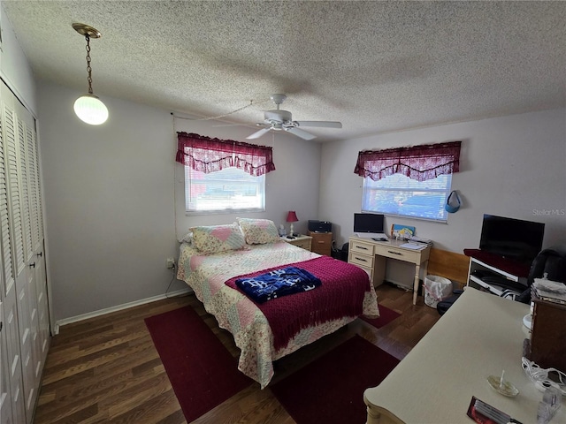 bedroom featuring baseboards, wood finished floors, a closet, and ceiling fan