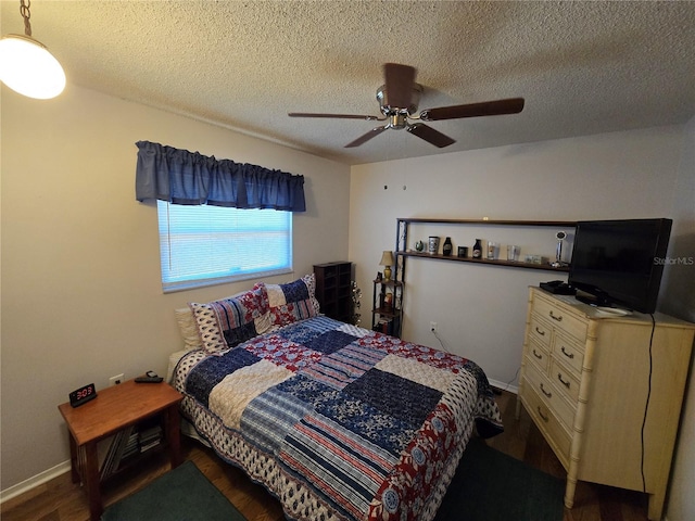 bedroom with a textured ceiling, wood finished floors, baseboards, and ceiling fan