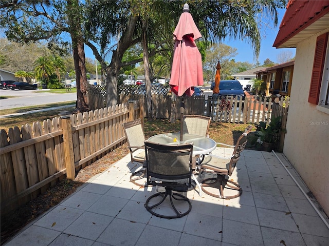 view of patio with outdoor dining space and fence