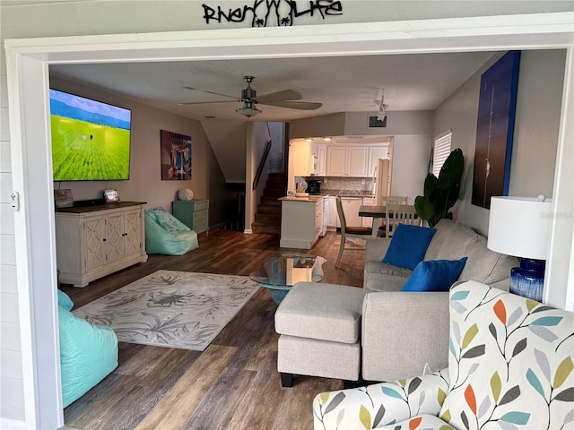 living room featuring a ceiling fan, stairway, and wood finished floors