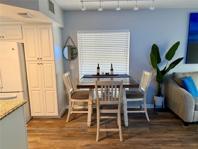 dining room featuring baseboards, a textured ceiling, visible vents, and dark wood-style flooring