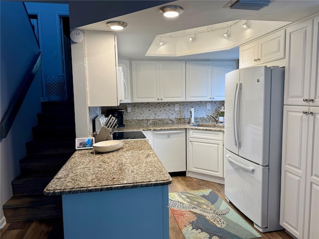 kitchen with white appliances, a sink, visible vents, white cabinets, and light wood finished floors