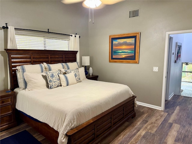 bedroom featuring a ceiling fan, dark wood-style flooring, visible vents, and baseboards