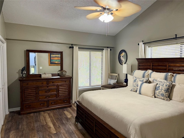 bedroom with dark wood-style floors, lofted ceiling, ceiling fan, a textured ceiling, and baseboards